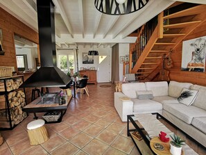 A spacious living area with a fireplace, wooden flooring, a white sofa, and a staircase. - 8, family or friends, share the Pyrenees (Villeneuve-de-Rivière)