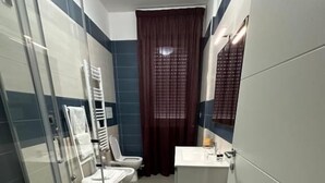 A modern bathroom with a glass shower enclosure, a toilet, and a sink. - Lotelito Apartment (Fisciano)
