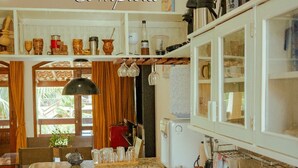 Una cocina con armarios blancos, encimera de granito y diversos utensilios.