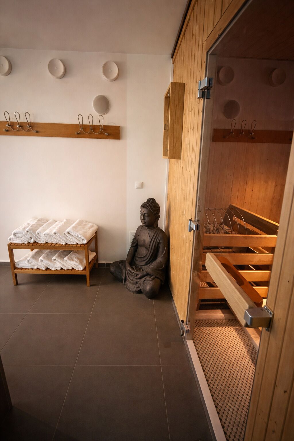 Une pièce avec un meuble en bois, une statue et un banc.