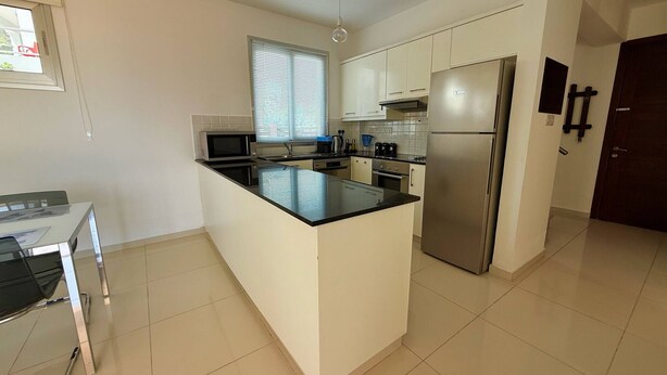 A modern kitchen with a central island, stainless steel appliances, and white cabinetry. - Amáni Seaview 3 Bedrooms Luxury Villa (Pegeia)