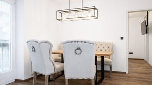 A dining area with two upholstered chairs, a wooden table, and a pendant light fixture. - 2-Schlafzimmer-Apartment mit Bergblick für 4–6 Personen (Alpenresidenz (Bad Gastein))