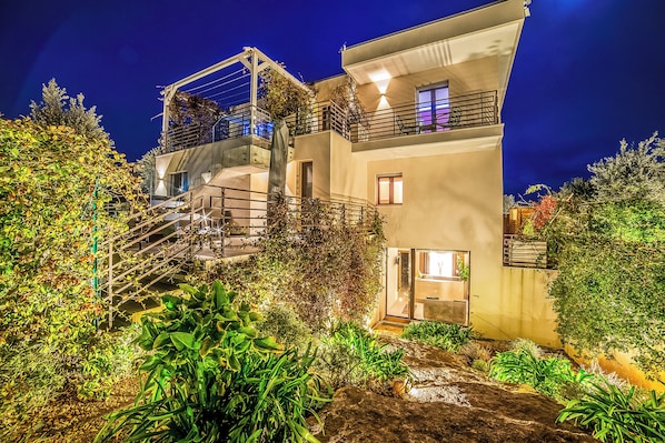 A modern two-story building with a balcony, a staircase, and a garden area. - Alternative Rooms Relax & SPA (Scorrano)