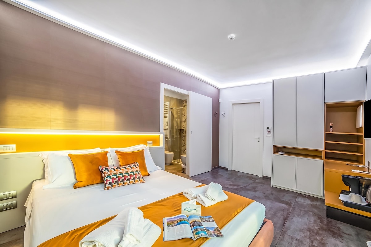 Una habitación de hotel con cama, escritorio, armario y baño.