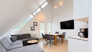 Un espace de vie moderne comprenant un canapé, une table à manger et un coin cuisine.
