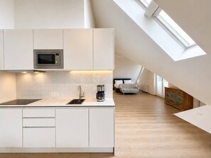 A modern kitchen with a built-in microwave, a coffee maker, and a sink. - 28 m² Studio mit Balkon für 2 Personen (Alpenresidenz (Bad Gastein))