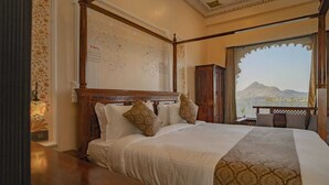 Una cama con dosel, una mesita de noche y vistas a las montañas.