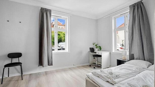 A modern bedroom with a bed, a desk, and a chair. - The Red House - Affordable living (Bergen)