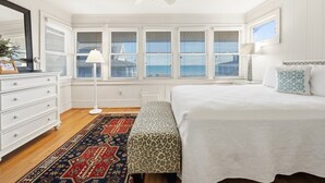 Un dormitorio con cama, mesita de noche, lámpara, cómoda, espejo y ventana con persianas.