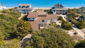 Una zona residencial costera con varias casas, una playa y una vista despejada del océano.