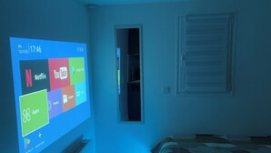 A bedroom with a bed, a dresser, and a wall-mounted TV displaying app icons. - Exclusive getaway with pool and jacuzzi (Clermont)