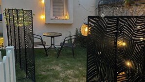 A small patio with a table and chairs, surrounded by decorative fencing and string lights. - Exclusive getaway with pool and jacuzzi (Clermont)