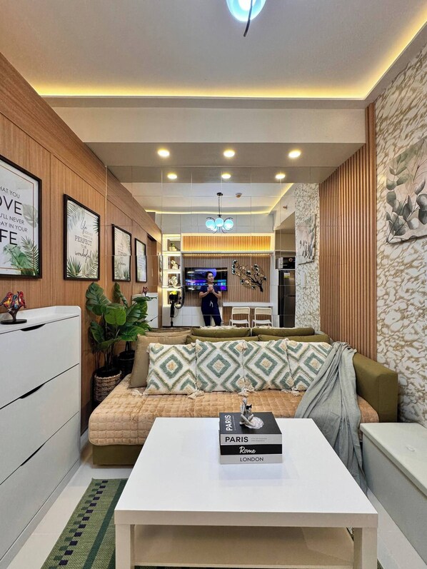 A modern living room with a sofa, a coffee table, and framed motivational quotes on the wall. - MJM Cityscape At Red Residences Makati (Makati)