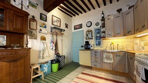 Una cocina con armarios de madera, microondas, cafetera y estufa.