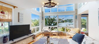 Dog-friendly riverfront home with dock, 2 balconies, waterside patio, & grill