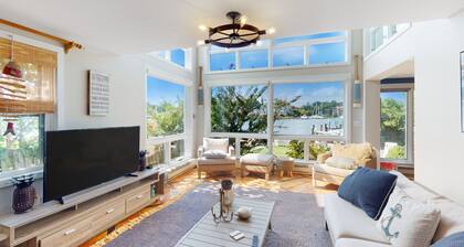 Dog-friendly riverfront home with dock, 2 balconies, waterside patio, & grill