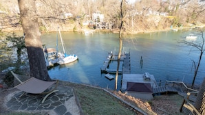 A lakeside view with a dock, a hammock, and a small shed.