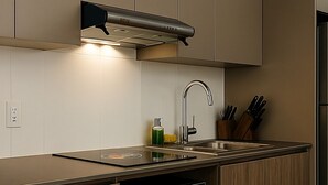 A modern kitchen with wooden cabinetry, a stainless steel sink, and a built-in oven. - Luxury STUDIO, Executive 3 minutes from the park (Quito)