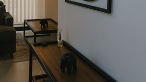 A modern living room with a minimalist design, featuring a sofa, a coffee table, and a wall-mounted mirror. - Luxury STUDIO, Executive 3 minutes from the park (Quito)