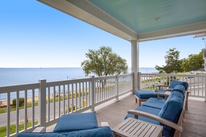 Eine überdachte Terrasse mit Blick auf Strand und Meer.