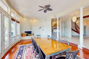 A spacious dining area with a large wooden table, multiple chairs, and a patterned rug. - Splendid home w/private pool, fire pit, several decks & balconies (Annapolis)