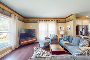 A living room with a TV, sofa, and coffee table. - Splendid dog friendly home within walking distance to beach & play area (Edgewater)
