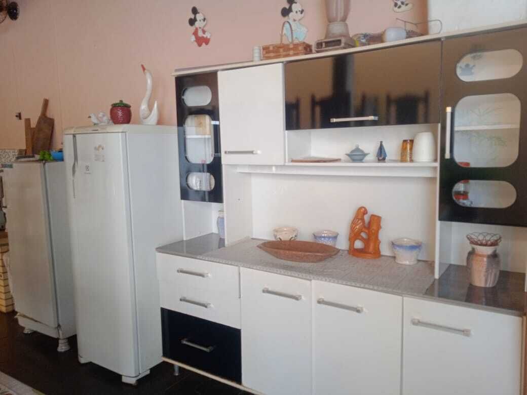 A kitchen with white cabinets, a countertop, and various kitchenware.