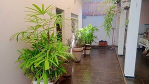 A corridor with potted plants, tiled flooring, and a door on the left. - House in Rifaina, with swimming pool, close to the beach. (Rifaina)