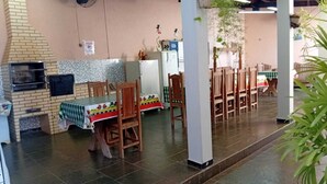 A restaurant with a brick oven, tiled walls, and wooden chairs. - House in Rifaina, with swimming pool, close to the beach. (Rifaina)