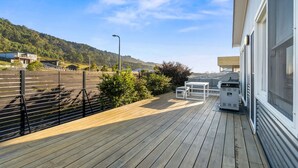 A wooden deck with outdoor furniture, a barbecue grill, and a view of a hilly landscape. - Days by the Bay (Apollo Bay)