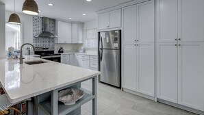 A modern kitchen with white cabinetry, stainless steel appliances, and pendant lighting. - 4 Beachside Home - Pet Friendly - Coastal Comfort Meets Stylish Island Living (Hilton Head Island)