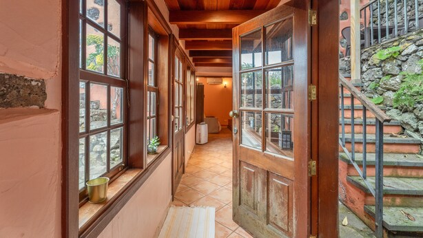 A hallway with large windows, a wooden ceiling, and a staircase. - Country House 'Gran Drago' with Sea View, Wi-Fi and Air Conditioning (Villa de Valverde)
