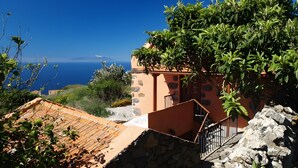 A building with a stone facade, a wooden roof, and a view of the sea. - Country House 'Gran Drago' with Sea View, Wi-Fi and Air Conditioning (Villa de Valverde)