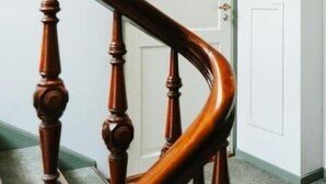 Uma escada de madeira com uma porta verde no topo.