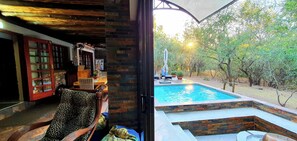 A room with a pool, wooden furniture, and a view of trees. - Loerie Escape – Luxury Bushveld Retreat Near Kruger Park in Marloth Park SA (Marloth Park)