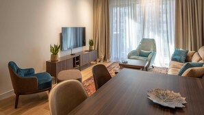 A modern living room with a wooden dining table, two sofas, a TV, and a large window with curtains. - Belgrade Waterfront Lux 3  (Belgrade)