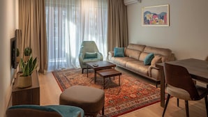A living room with a sofa, armchairs, a coffee table, and a dining table. - Belgrade Waterfront Lux 3  (Belgrade)