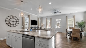 A spacious kitchen with a large island, pendant lights, and a ceiling fan. - Beautime-Pet Friendly Home in Downtown Beaufort, NC (Beaufort)