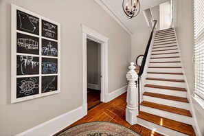 A staircase with wooden steps and a white balustrade, leading to a room with a white door. - Bright 2BR Historic Apartment Overlooking Forsyth Park by Lucky Savannah (Savannah)