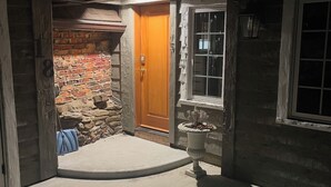 Une maison avec une porte en bois, un mur en briques et une fenêtre.
