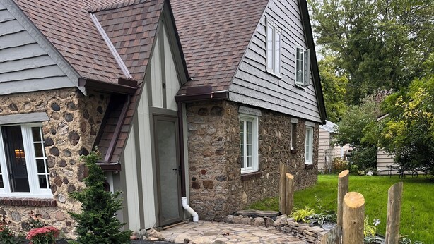 Une maison en pierre avec un chemin en pierre menant à l’entrée.
