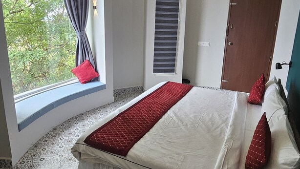 Un dormitorio con una cama grande, una ventana con cortinas, una puerta y un piso con diseño.