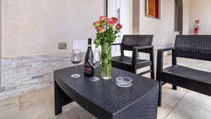 Ein Tisch mit einer Blumenvase, zwei Weingläsern und einer Weinflasche.
