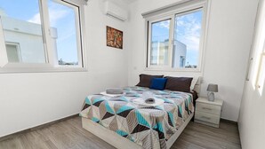 Una camera da letto con un letto, un comodino, una lampada e un quadro appeso al muro.