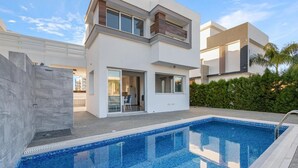 Una moderna casa a due piani con piscina.