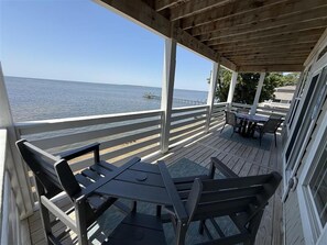 Une terrasse couverte avec vue sur l’océan, comprenant une table et des chaises.