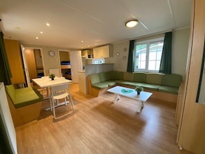 A compact living space with a dining area, a sofa, and a kitchenette.