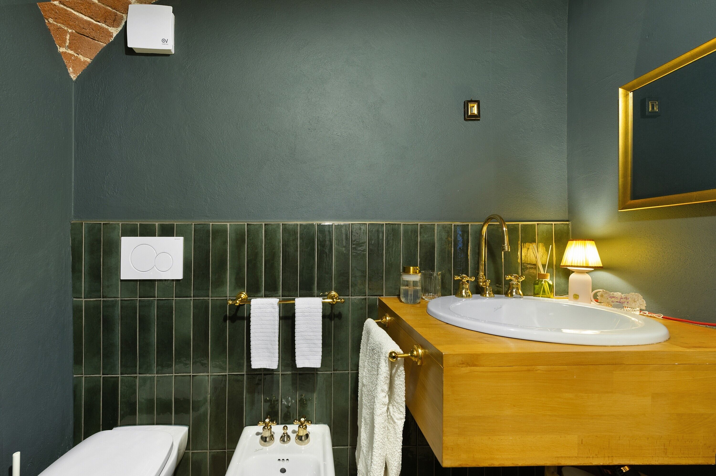 Ein Badezimmer mit Waschbecken, Spiegel, Handtuchhalter und Toilette.