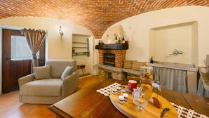 Ein gemütliches Wohnzimmer mit Kamin, einer Couch und einem Couchtisch mit Gegenständen darauf.