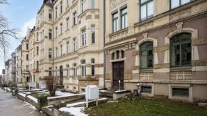 Eine Reihe historischer Gebäude mit einheitlicher Architektur, ein Bürgersteig und ein Fahrrad davor.